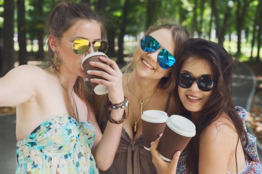 Üç güzel genç boho chic şık kız Parkta yürümek.