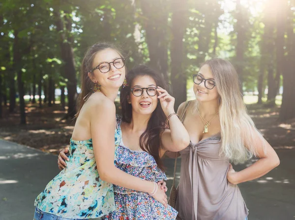 Three beautiful young boho chic stylish girls walking in park. — Stock Photo, Image