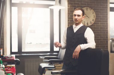 Kuaför berber dükkanında, sandalyeye otur davet ediyor