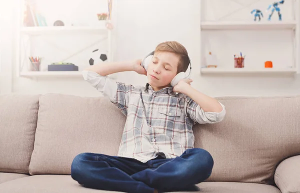 Tonårspojke njuter av musik i hörlurar hemma — Stockfoto