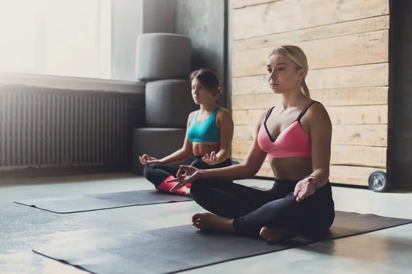 Jovens mulheres na aula de ioga, relaxar pose meditação — Fotografia de Stock