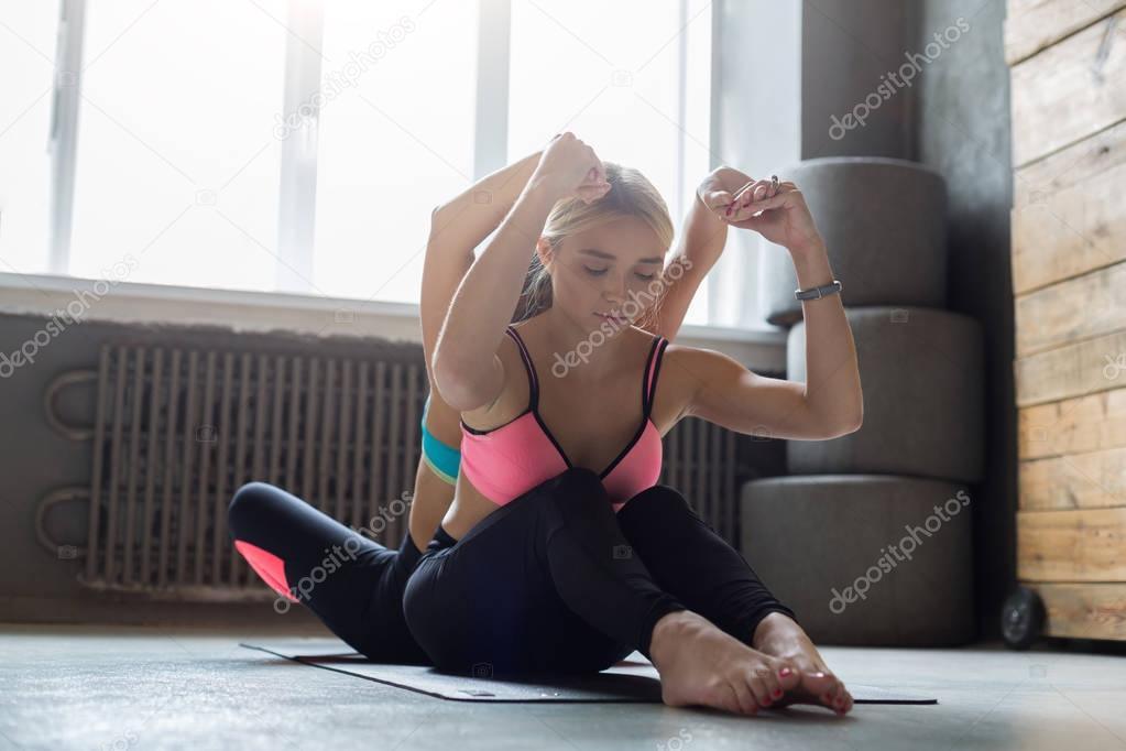Woman with yoga instructor in class, back bend stretching