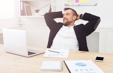 Genç işadamı modern beyaz ofis içinde laptop ile rahat