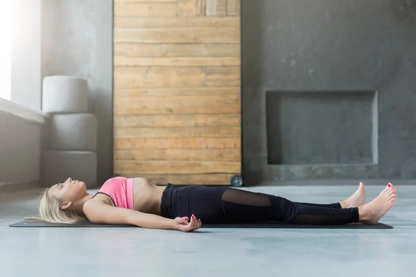 Young woman in yoga class, relax meditation corpse pose — Stock Photo, Image