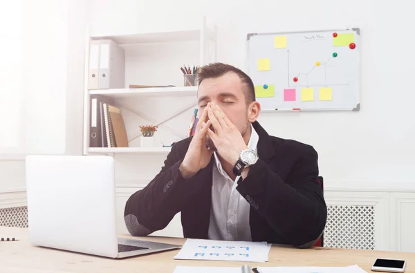 Young benadrukt zakenman met laptop in moderne witte kantoor — Stockfoto