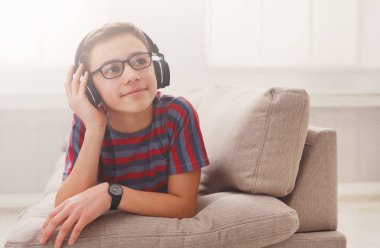 Genç çocuk evde kulaklık müzik keyfi