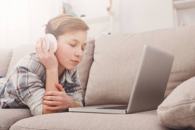 Genç çocuk evde kulaklık müzik keyfi