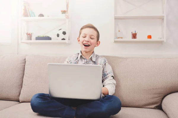 Tizenéves fiú használ a laptop otthon a kanapén — Stock Fotó