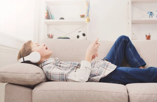 Teenage boy enjoying music in headphones at home — Stock Photo, Image