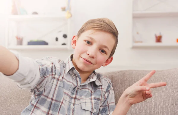 Erkek çocuk evde telefonla selfie alarak