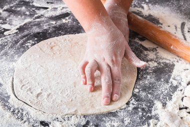 Fırın kavramı. El hamur siyah arka plan üzerine rulo..