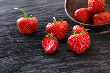 Siyah rustik ahşap zemin üzerine kırmızı taze çilek