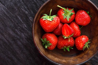 Siyah rustik ahşap zemin üzerine kırmızı taze çilek