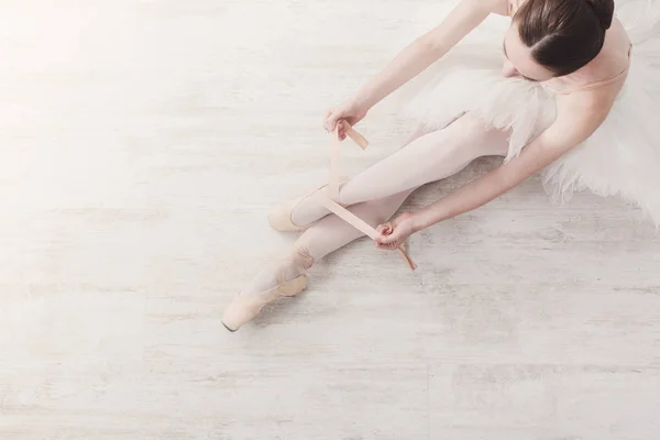 Балерина надевает пуанты балетные туфли, изящные ноги — стоковое фото