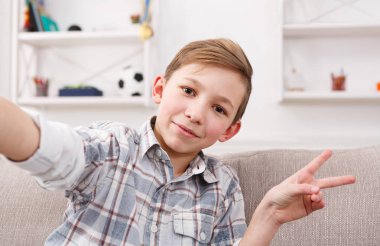 Erkek çocuk evde telefonla selfie alarak