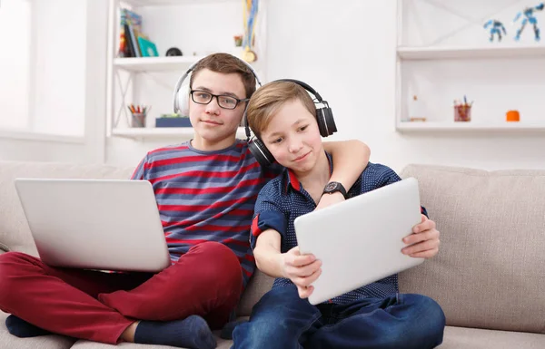 Due ragazzi adolescenti che utilizzano tablet sul divano a casa — Foto Stock