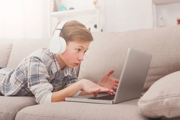 十几岁的男孩在家里的沙发上使用笔记本电脑 — 图库照片