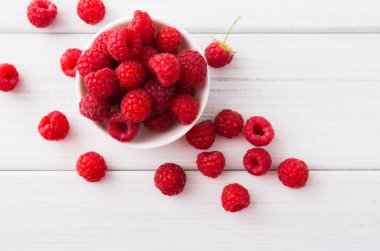 Beyaz rustik ahşap arka plan üzerinde kırmızı taze frambuaz