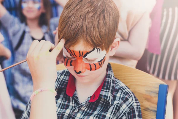 Niño niño cara pintura, haciendo tigre ojos proceso — Foto de Stock