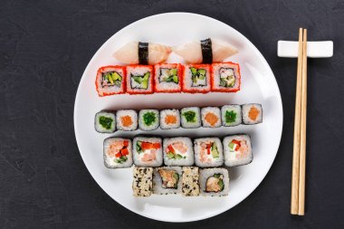 Suşi ve siyah arka plan, üstten görünüm üzerinde rulo