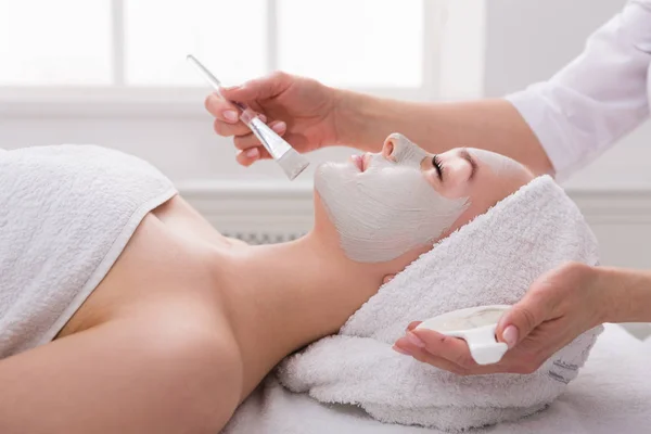 Mujer consigue máscara facial por esteticista en el spa —  Fotos de Stock