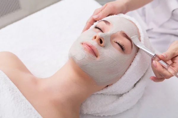 Mujer consigue máscara facial por esteticista en el spa —  Fotos de Stock