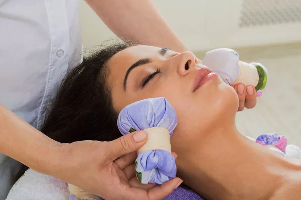 Woman has herbal ball massage in ayurveda spa wellness center — Stock Photo, Image