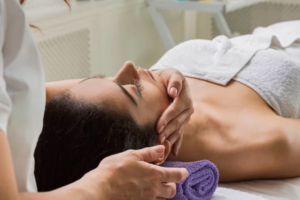 Mulher esteticista médico fazer massagem na cabeça no centro de bem-estar spa — Fotografia de Stock