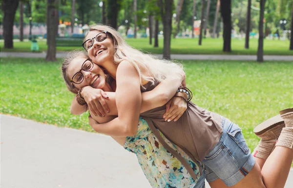 Zwei glückliche junge Mädchen umarmen sich im Sommerpark — Stockfoto