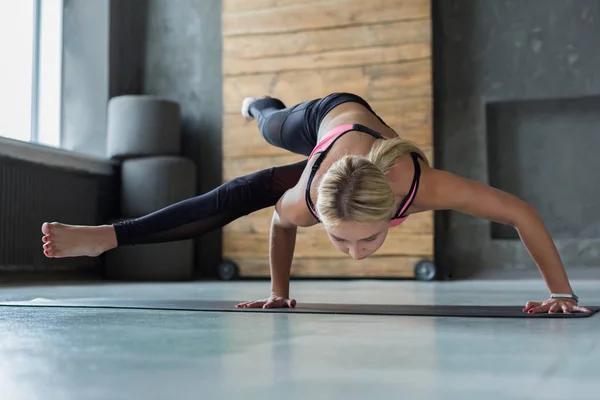 Mujer joven en clase de yoga, Eight-Angle Pose asana —  Fotos de Stock