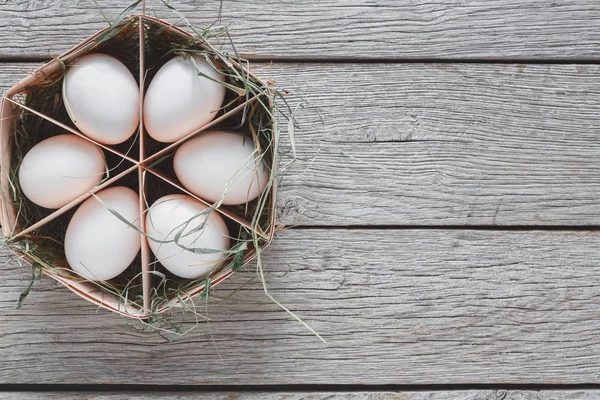 Ovos brancos de galinha frescos na caixa no fundo de madeira rústica — Fotografia de Stock