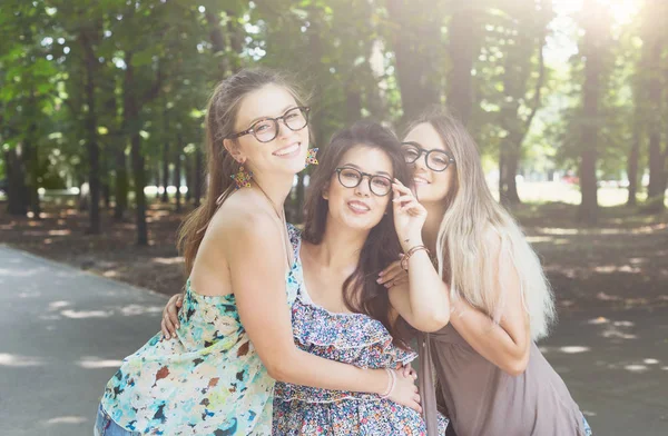 Три красивые молодые шикарные стильные девушки, гуляющие в парке . — стоковое фото