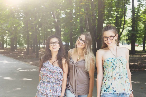 Drie mooie jonge boho chique stijlvol meisjes lopen in park. — Stockfoto