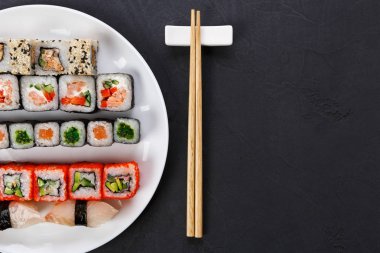 Suşi ve siyah arka plan, üstten görünüm üzerinde rulo