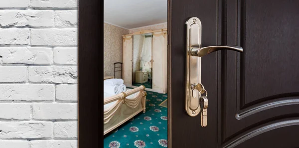 Puerta medio abierta de un dormitorio clásico, manija de primer plano . — Foto de Stock