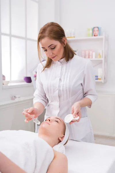 Frau bekommt Gesichtsmaske von Kosmetikerin im Spa — Stockfoto