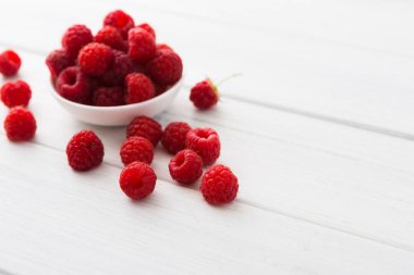 Beyaz rustik ahşap arka plan üzerinde kırmızı taze frambuaz