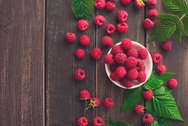 Kahverengi rustik ahşap arka plan üzerinde kırmızı taze frambuaz