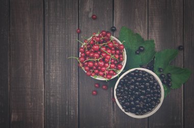 Rustik ahşap kase üstten görünüm arka plan siyah ve kırmızı kuş üzümü