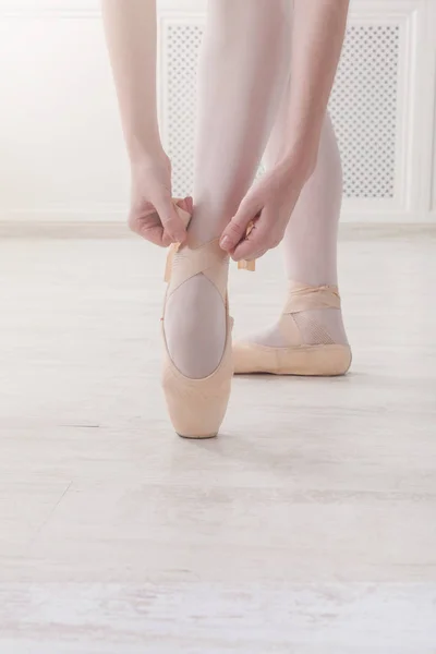 Pernas de close-up de bailarina coloca em sapatos de ballet pointe — Fotografia de Stock