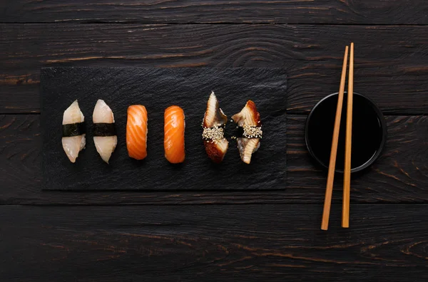 Set of sushi on black wood background, top view — Stock Photo, Image