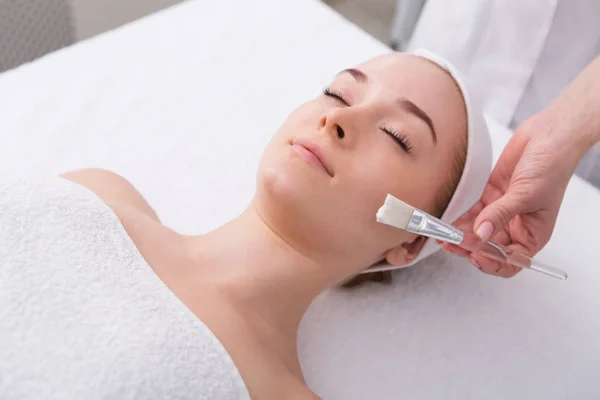 Kvinna får ansiktsmask av kosmetolog på spa — Stockfoto