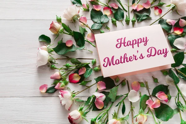 Mothers day background, card and flowers on white wood
