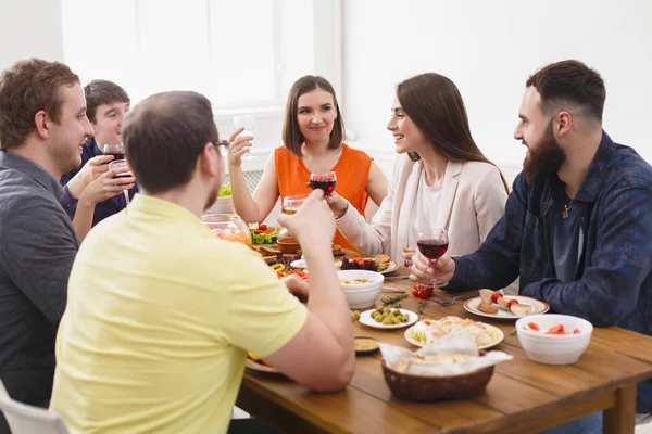 Skupina happy mladých lidí u jídelního stolu, strana přátel — Stock fotografie