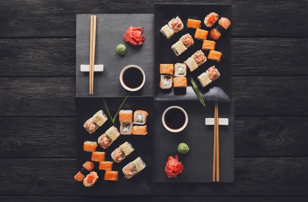 Set sushi maki en broodjes op zwarte rustieke houten, top uitzicht — Stockfoto