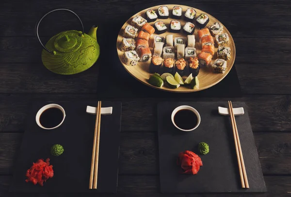 Zestaw sushi z łososiem i bułki na czarnym tle, widok z góry — Zdjęcie stockowe