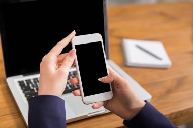 Dizüstü bilgisayar ve akıllı telefon kullanan kadın Close-Up