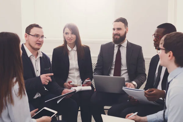 Reunión de negocios. Jóvenes hombres y mujeres de negocios en la oficina moderna — Foto de Stock