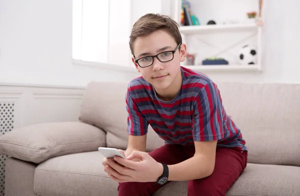 Adolescent avec téléphone portable dans le salon à la maison — Photo