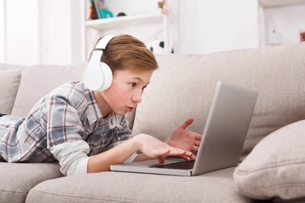 Tiener met behulp van de laptop op de Bank thuis — Stockfoto